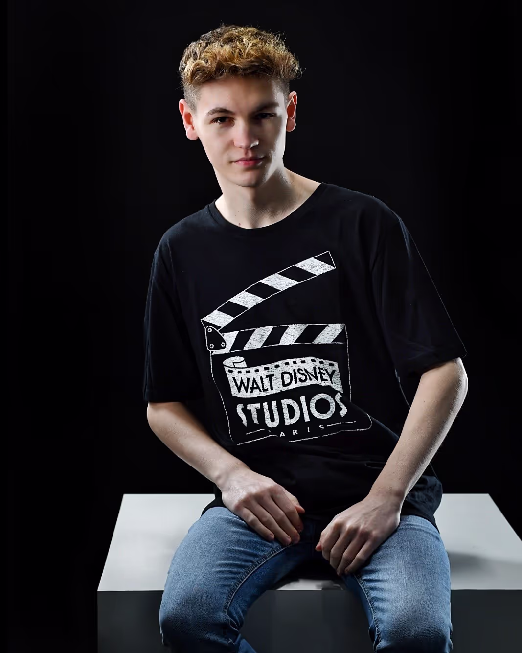 Dylan on a white block in a studio setting.