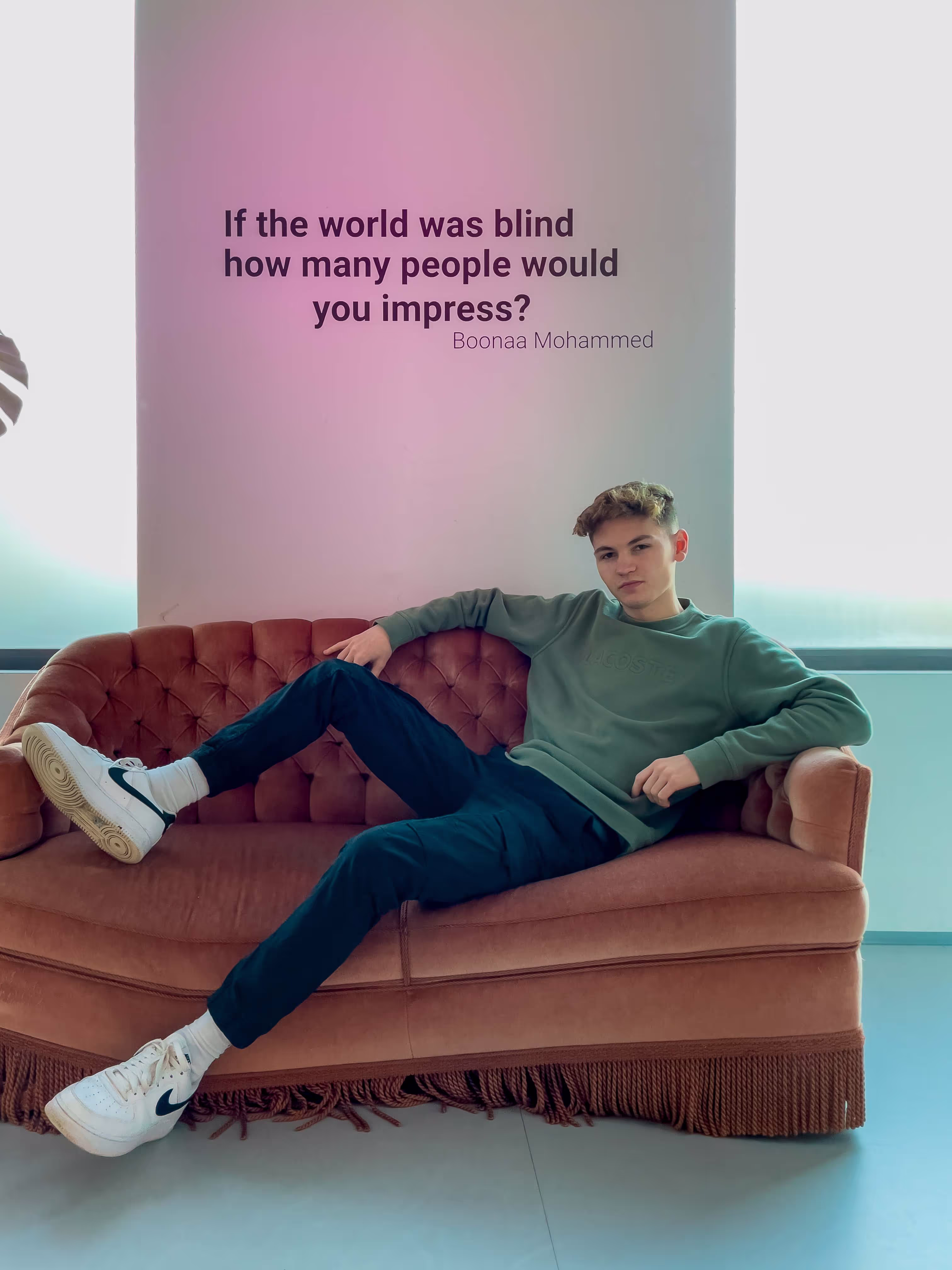 Dylan on a large couch with a quote in the background.